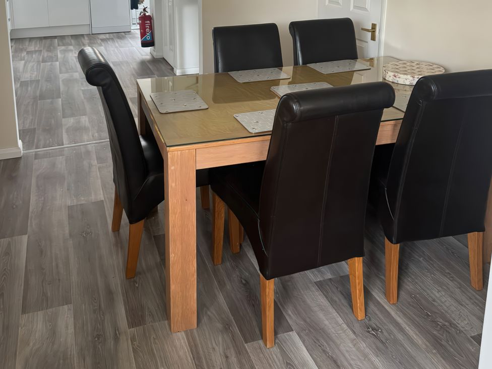 A dining table with black chairs and placemats at The Garden House in Whitstable