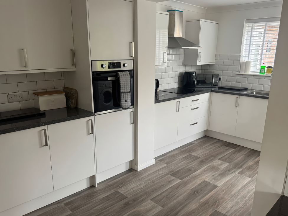 A kitchen with cabinets, oven, microwave, and sink at The Garden House in Whitstable
