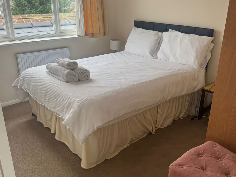 A bedroom with a bed and towels at The Garden House in Whitstable