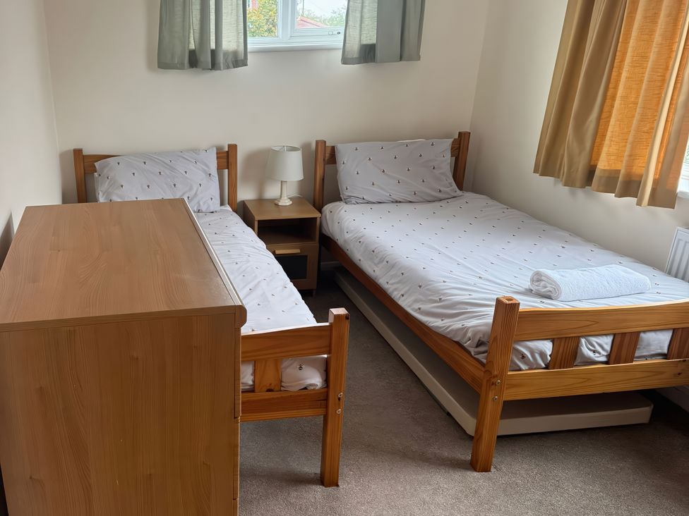 A bedroom with two single beds and a nightstand at The Garden House in Whitstable
