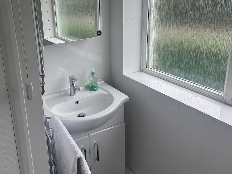 A bathroom with a sink and mirror at The Garden House in Whitstable