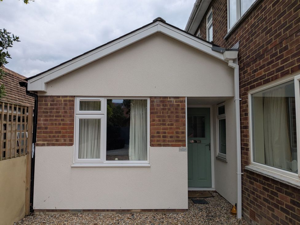 An outdoor view of a house entrance with a green door at The Garden House Cottage in Whitstable