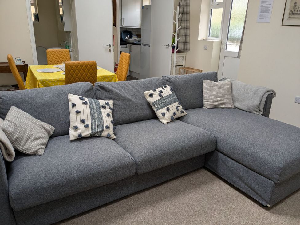 A living room with a sofa and dining area at The Garden House Cottage in Whitstable