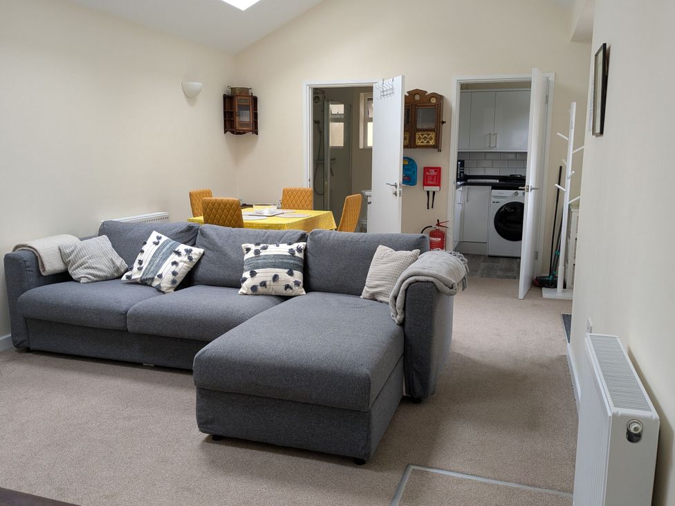 A living room with a sofa and dining area at The Garden House Cottage in Whitstable