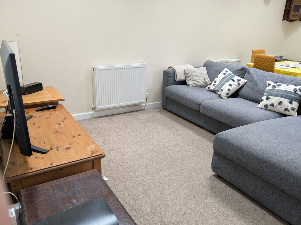 A living room with a sofa and television at The Garden House Cottage in Whitstable