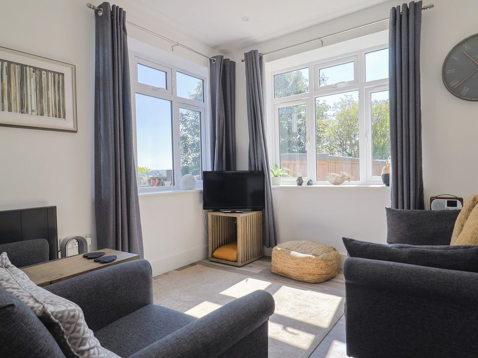 A living room with a television and sofa at Lyme Zest in Lyme Regis