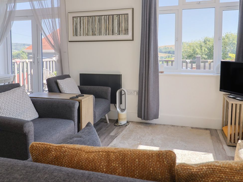 A living room with chairs and a table at Lyme Zest in Lyme Regis