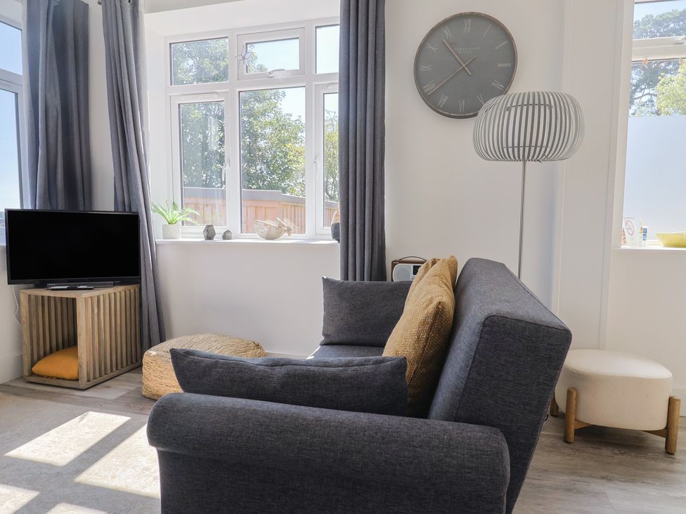 A living room with a sofa and television at Lyme Zest in Lyme Regis