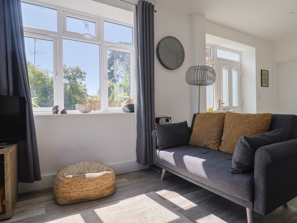 A living room with a sofa and television at Lyme Zest in Lyme Regis