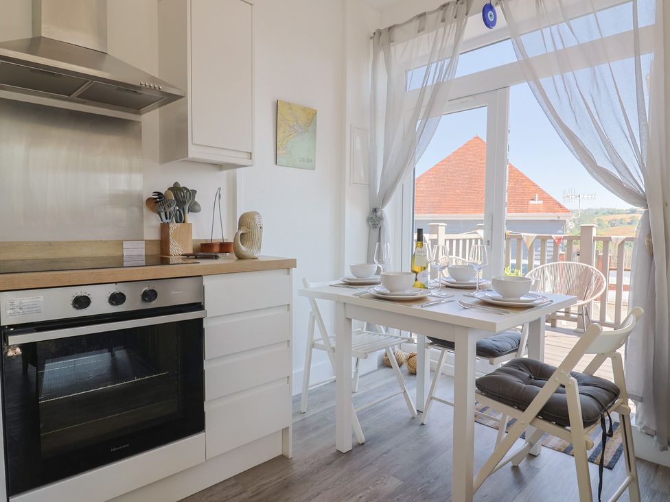 A kitchen with a table and chairs at Lyme Zest in Lyme Regis