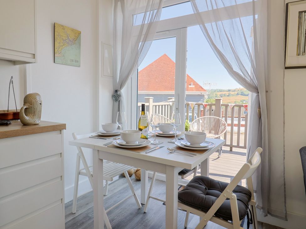 A dining room with a table set for a meal at Lyme Zest in Lyme Regis
