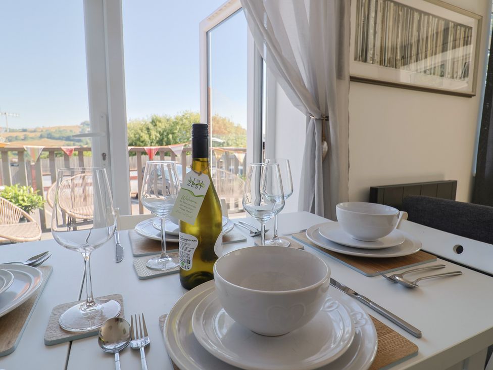 A dining table set with wine, glasses, and dishes at Lyme Zest in Lyme Regis