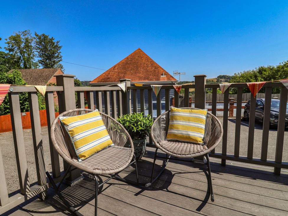 An outdoor seating area with two chairs and a planter at Lyme Zest in Lyme Regis