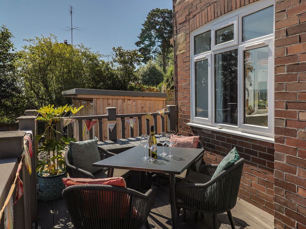 An outdoor seating area with a table and chairs at Lyme Zest in Lyme Regis