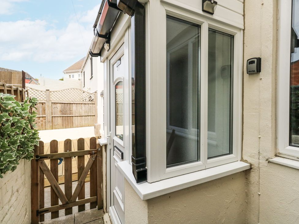 An outdoor area with a gate and windows at Saddlers Cottage in Weymouth
