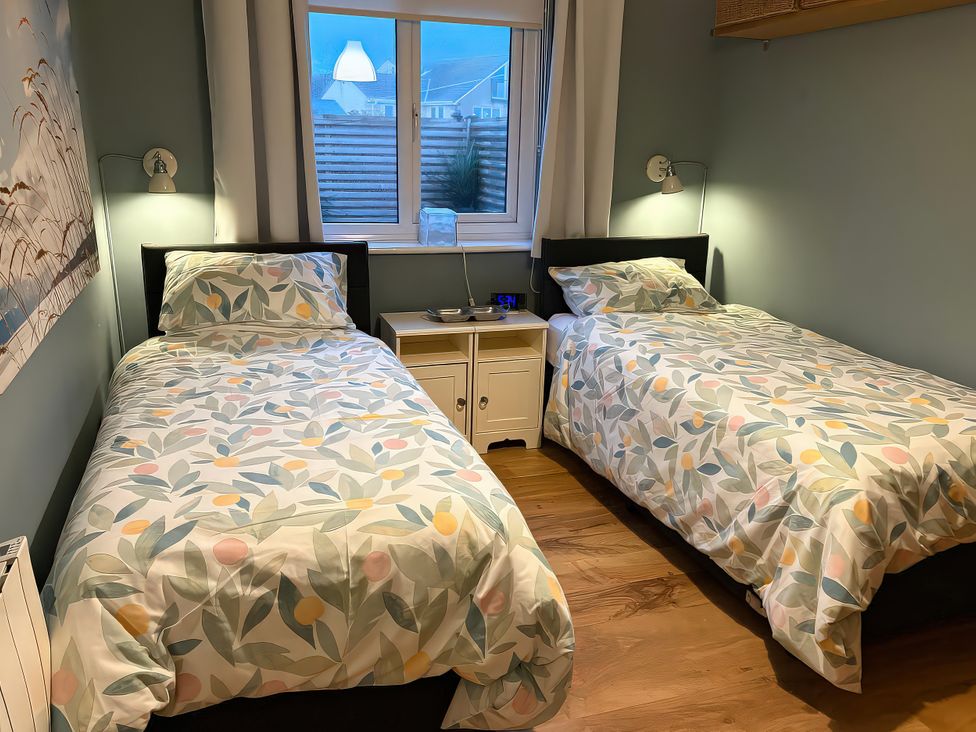 A bedroom with two beds and a window at Seaspray in St Bees