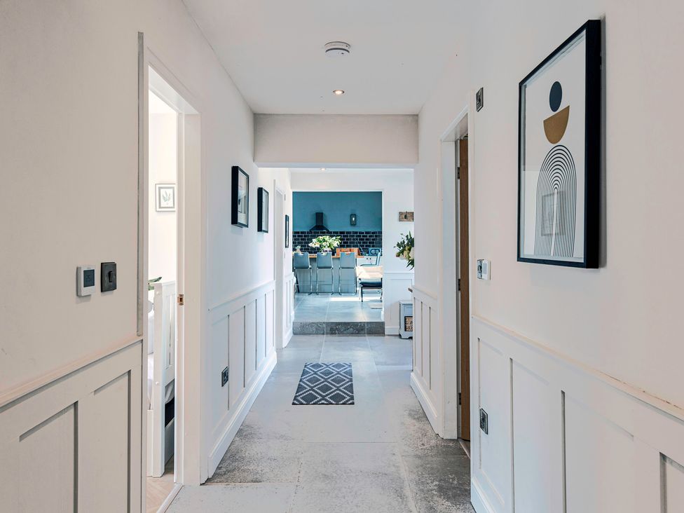 A hallway with framed pictures and a rug at Fairvale House in 