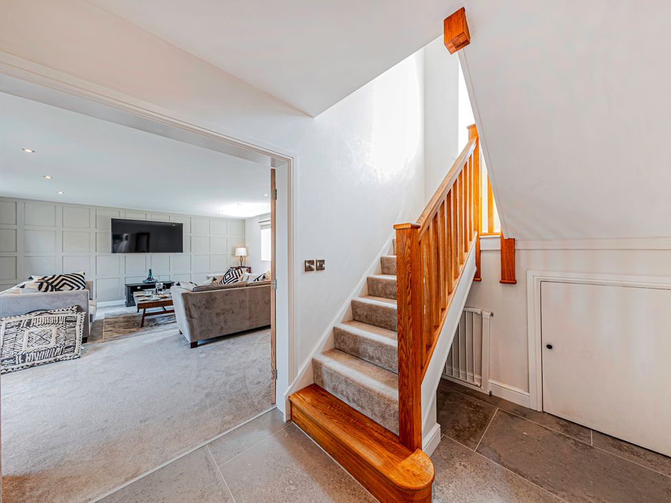 A hallway with staircase and access to living area at Fairvale House