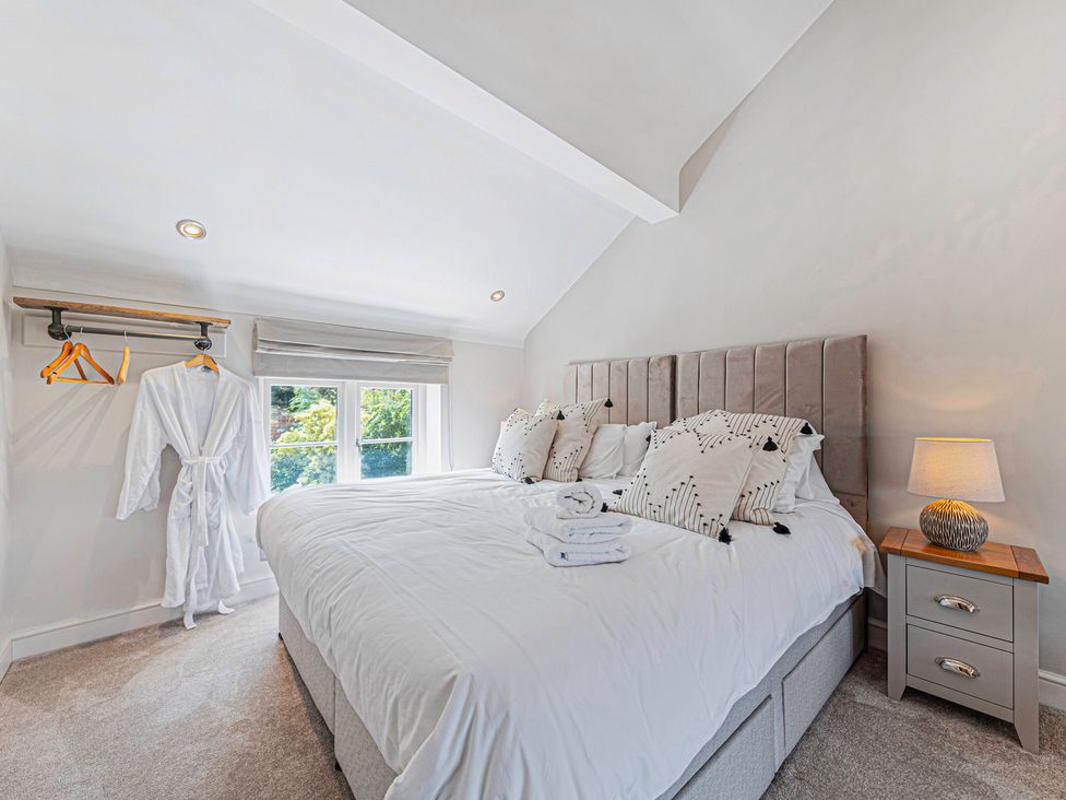 A bedroom with a bed and robes at Fairvale House 