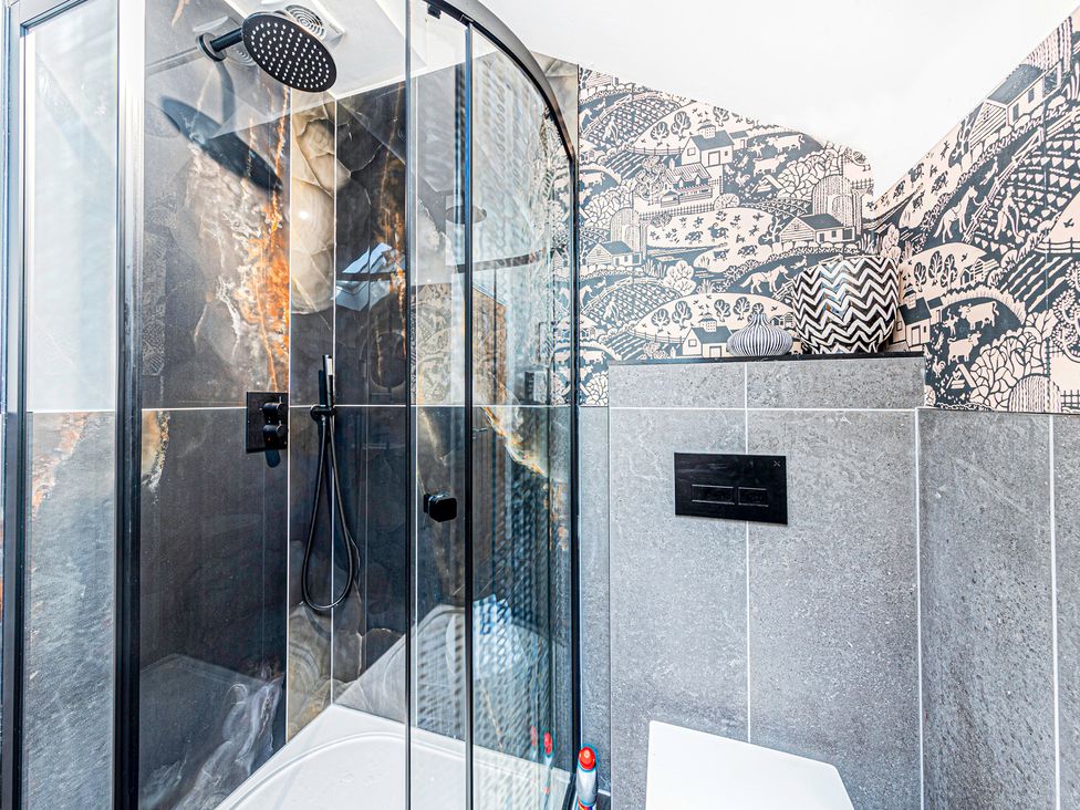 A shower with glass door and decorative vase in the bathroom at Fairvale House