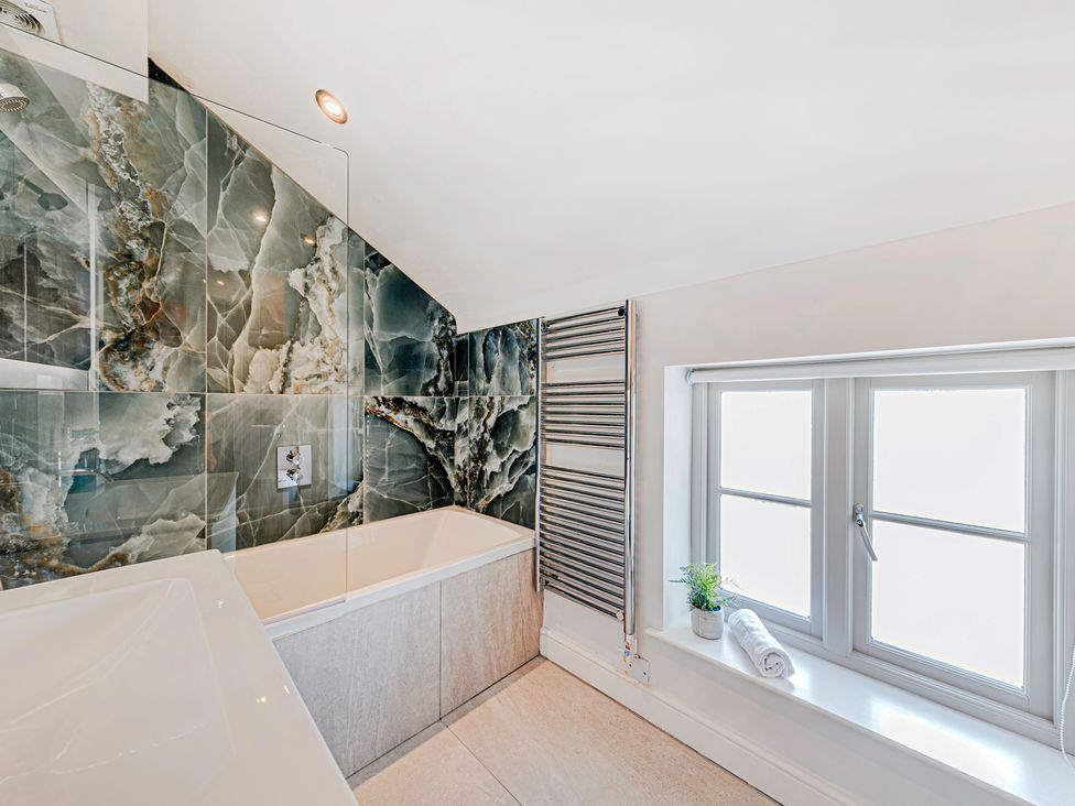 A bathroom with a bath tub and window at Fairvale House