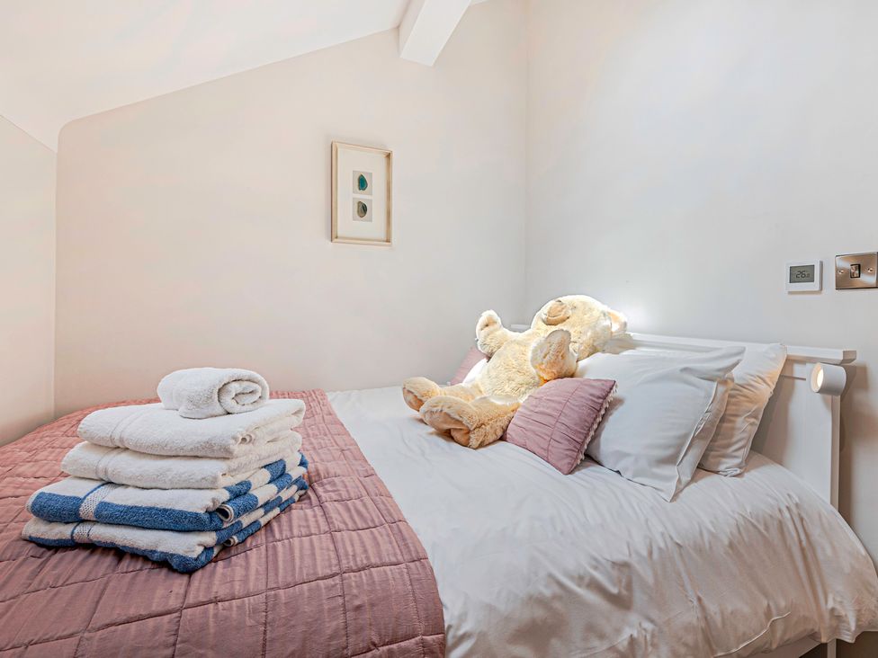 A bedroom with a bed, towels, and a teddy bear at Fairvale House