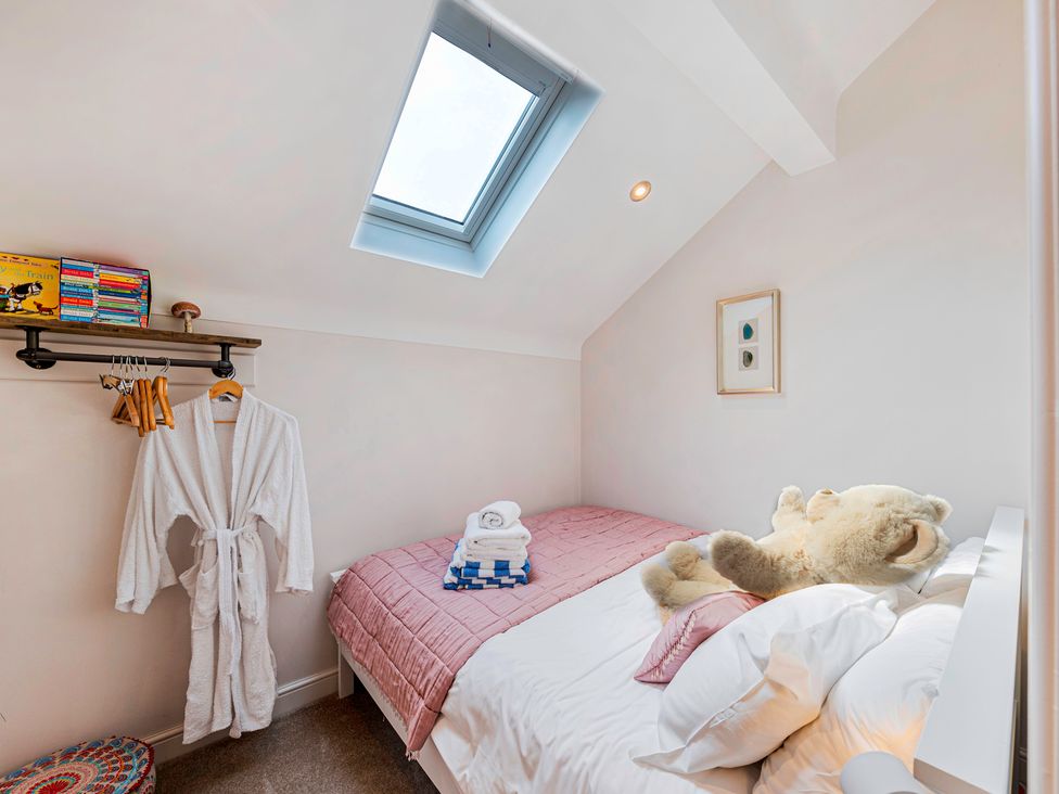 A bedroom with a bed and shelves at Fairvale House