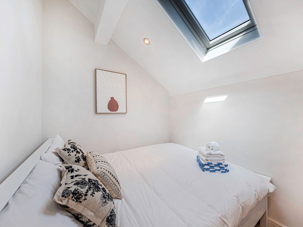 A bedroom with a bed and towels stacked at Fairvale House