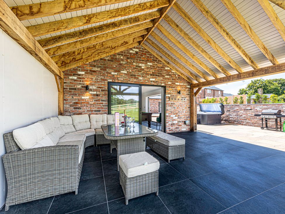 An outdoor sitting area with furniture and barbecue at Fairvale House in 