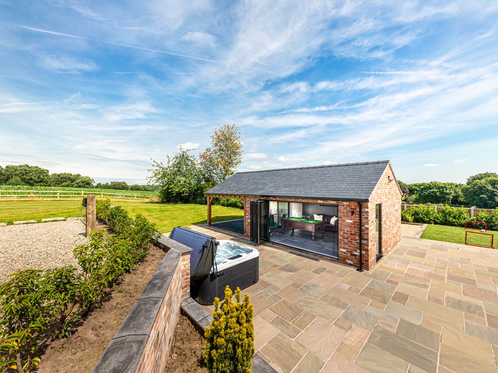 An outdoor area with a hot tub and a brick building at Fairvale House