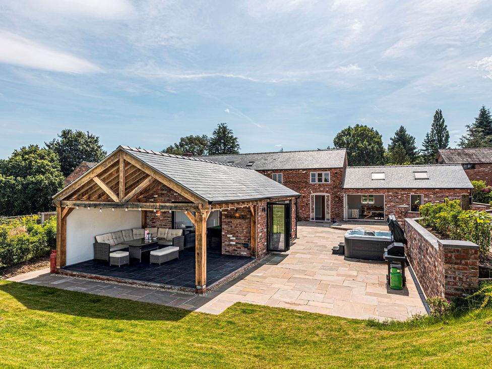 An outdoor seating area with a structure and hot tub at Fairvale House
