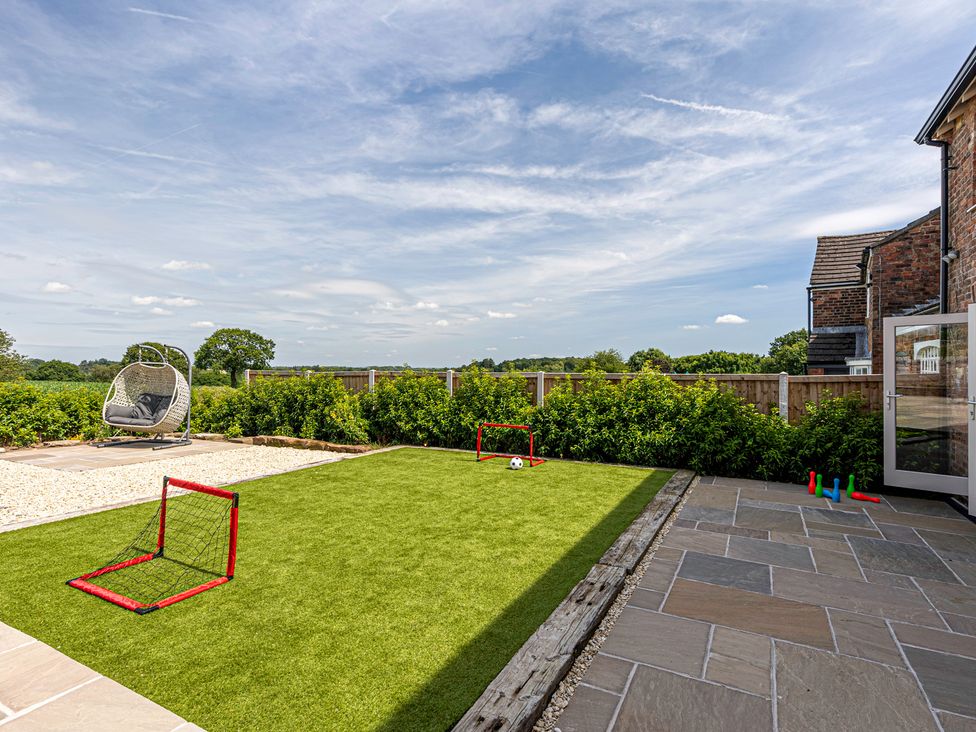 A garden with a hanging chair and soccer goals at Fairvale House