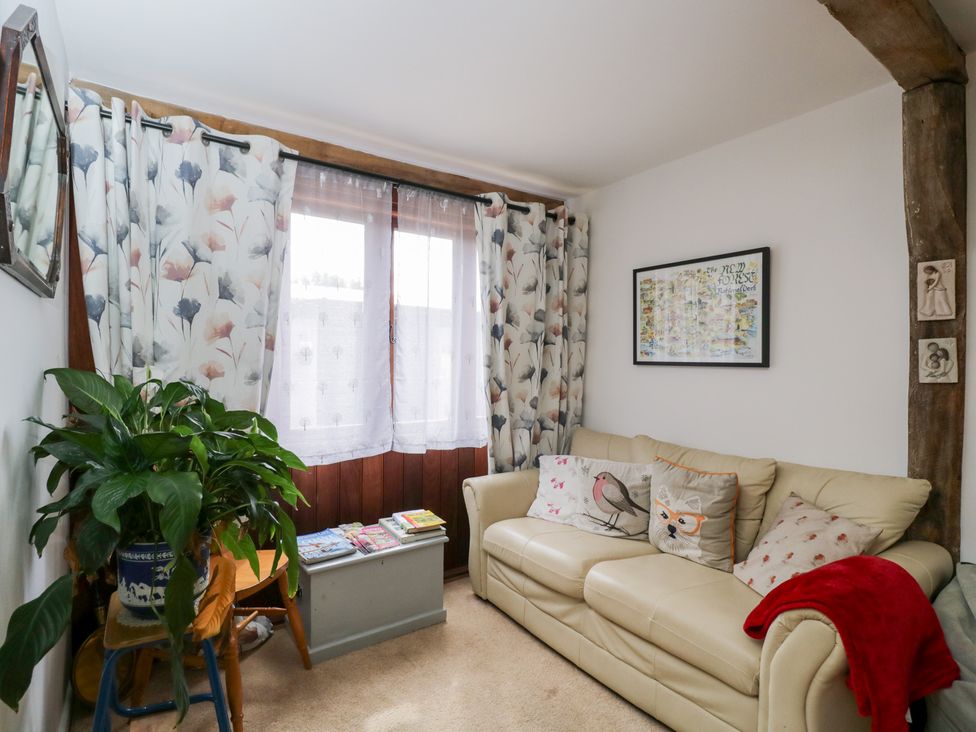A living room with a sofa and a houseplant at The Old Byre in Woodfalls