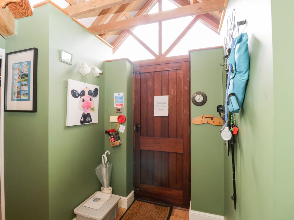 A hallway with a door, picture, and fire extinguisher at The Old Byre in Woodfalls