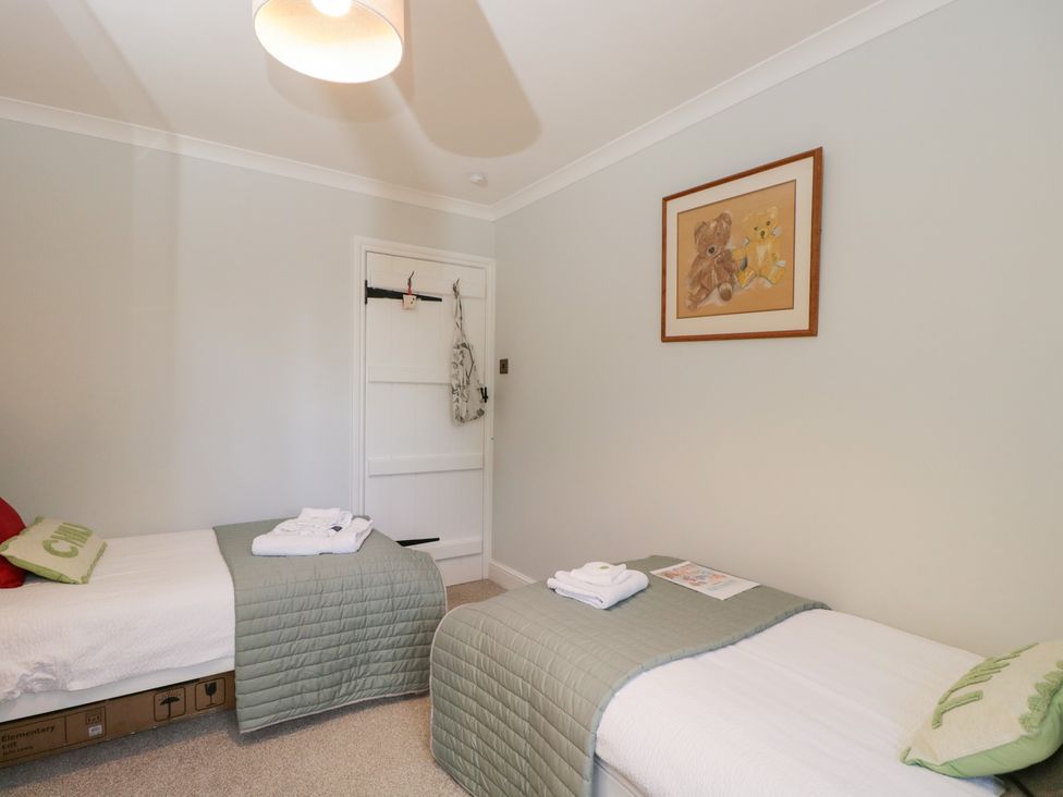 A bedroom with two beds and a painting at The Old Byre in Woodfalls