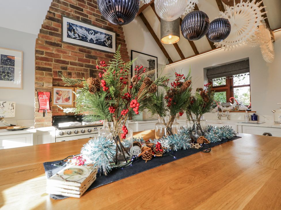 A kitchen with a dining table decorated with vases and festive elements at The Old Byre in Woodfalls