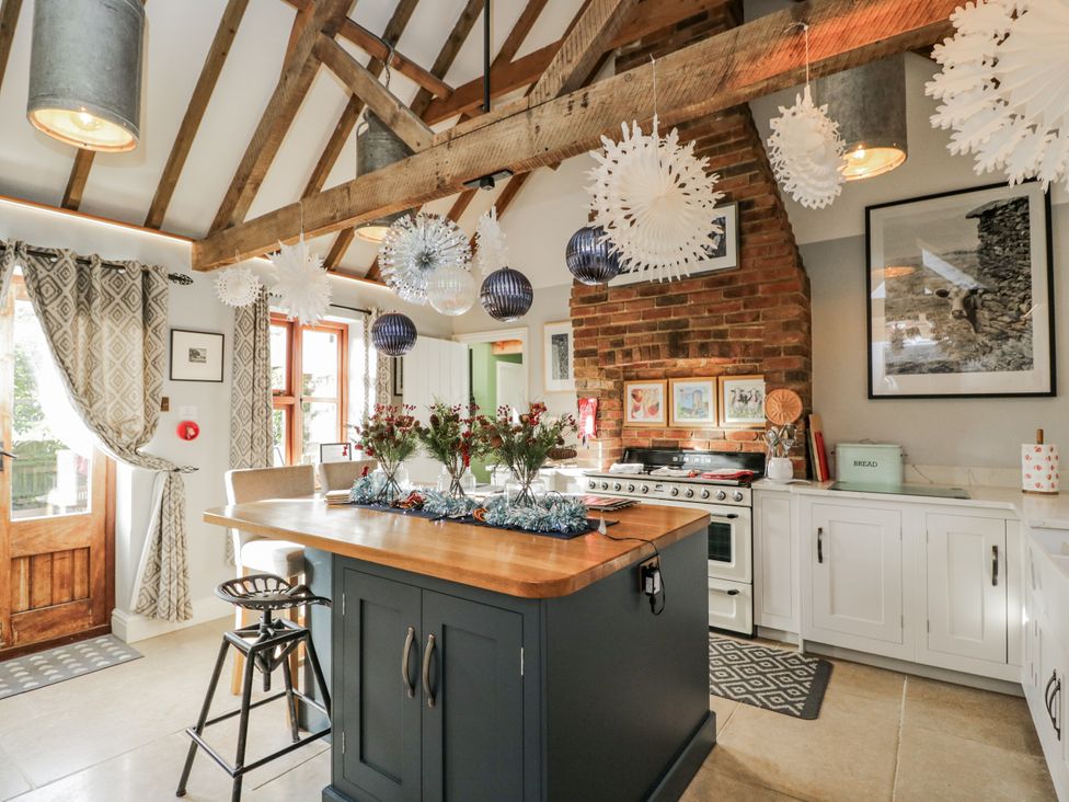 A kitchen with a central island and stove at The Old Byre in Woodfalls