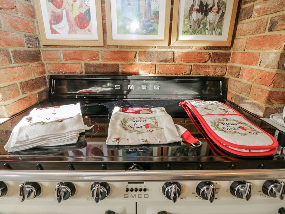 A kitchen with an oven and decorative tea towels at The Old Byre in Woodfalls