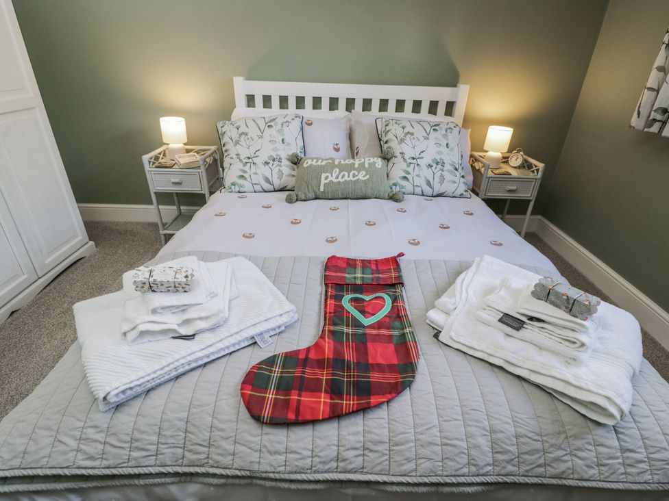 A bedroom with a bed made and towels on display at The Old Byre in Woodfalls