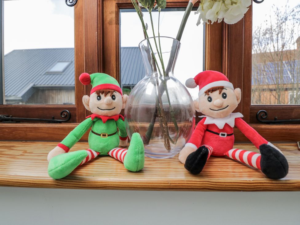 Two elf plush toys and a vase on a wooden shelf at The Old Byre in Woodfalls