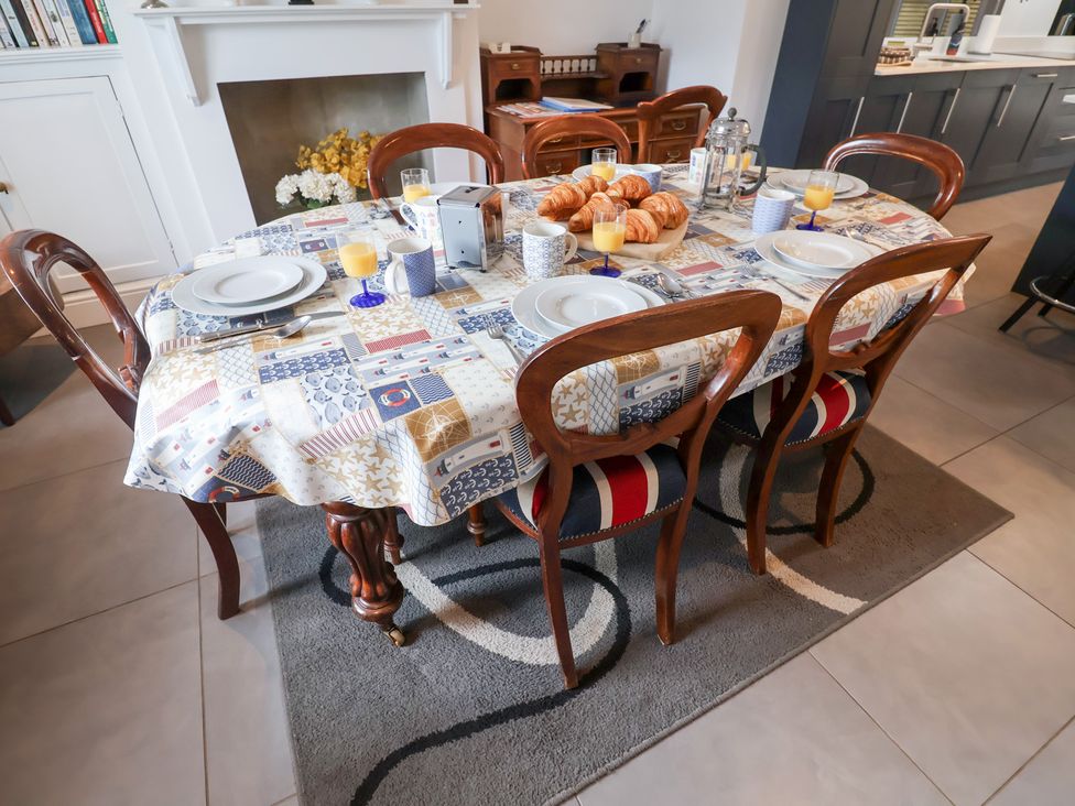 A dining room with a table set for breakfast at Cavan Cottage in Yoxford