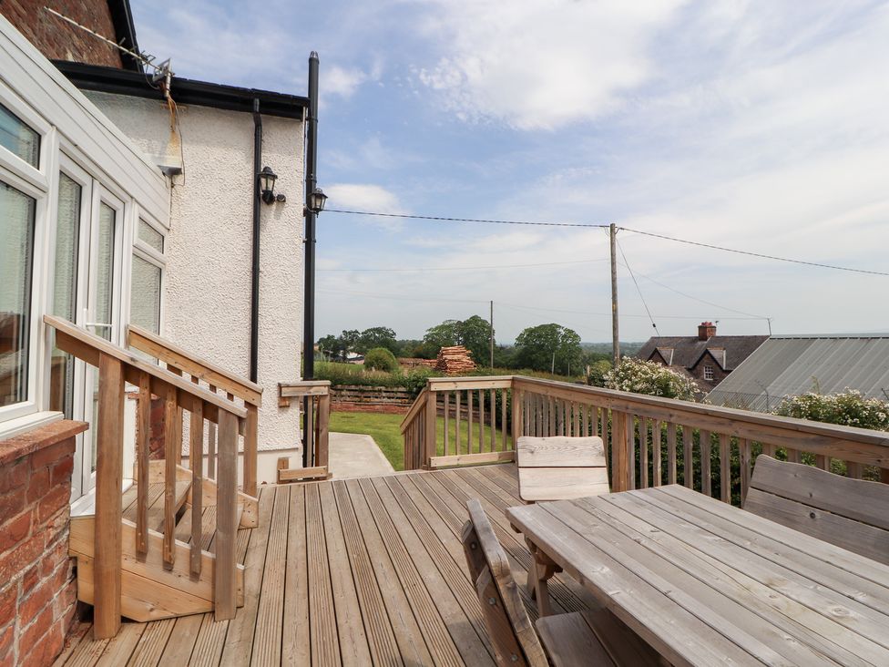 A deck area with table and chairs at Rose Bank Cottage in Dalston