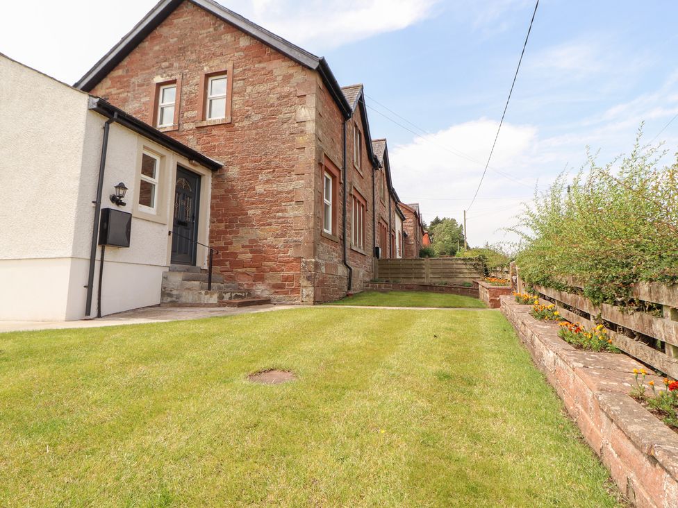 A house with a lawn and steps at Rose Bank Cottage in Dalston