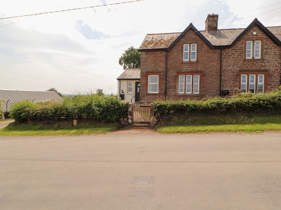 A house with a gate and hedge at Rose Bank Cottage in Dalston