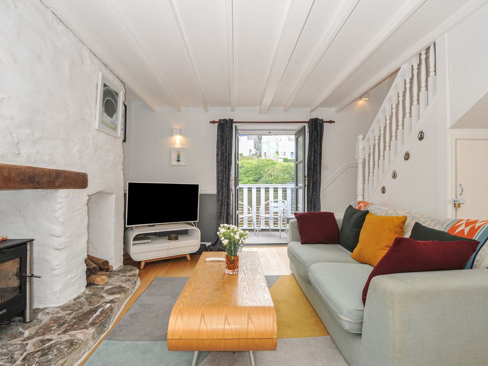 A living room with a sofa, coffee table, and television at 3 River View in Looe