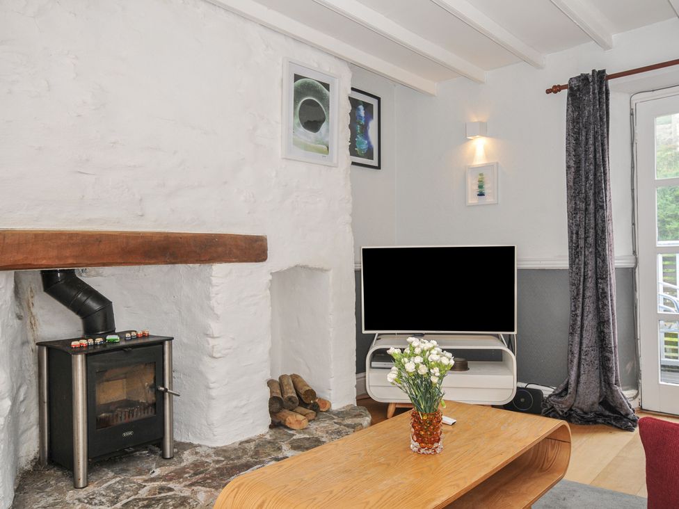 A living room with a television and a fireplace at 3 River View in Looe