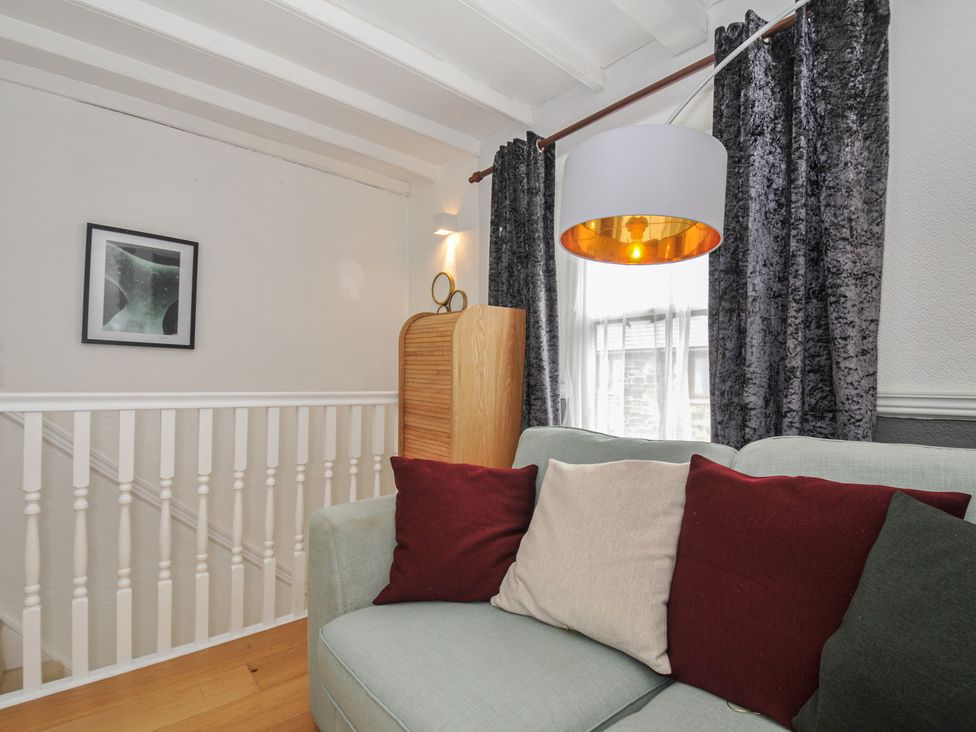 A living room with a sofa and cushions at 3 River View in Looe