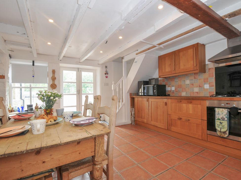 A kitchen with a table and chairs at 3 River View Looe