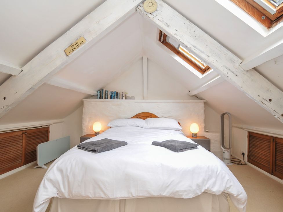 A bedroom with a bed and bedside lamps at 3 River View in Looe