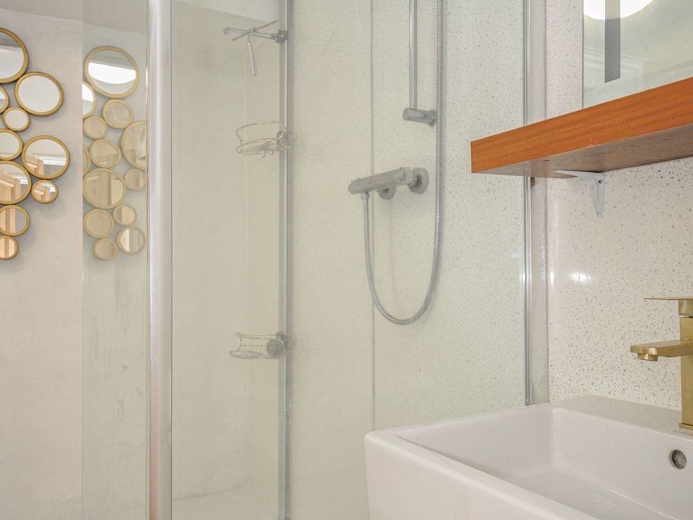A bathroom with a shower and sink at 3 River View in Looe